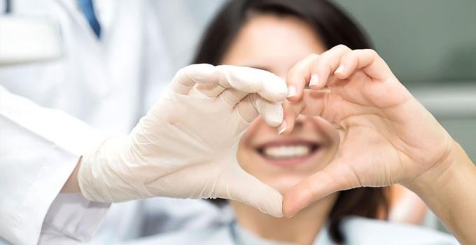 Dentist and Patient making heart with hands